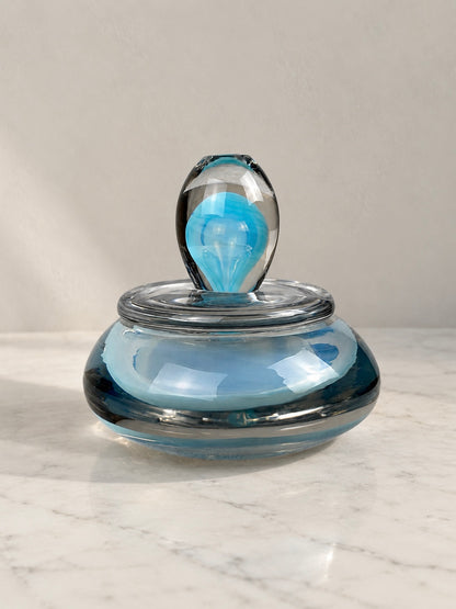 Murano art glass lidded dish with a rounded blue and smoky grey glass body, clear glass cover and sculptural turquoise-blue finial.