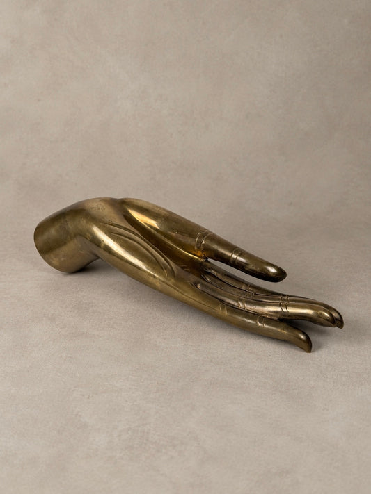 Sculptural brass hand with an elongated open palm, engraved finger detailing and a naturally aged golden brass finish.