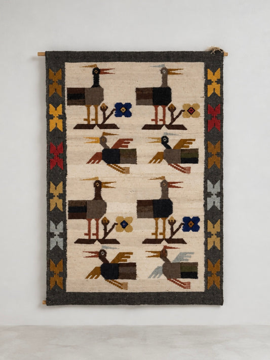 South American handwoven wool flat weave tapestry with stylised bird motifs and geometric border.