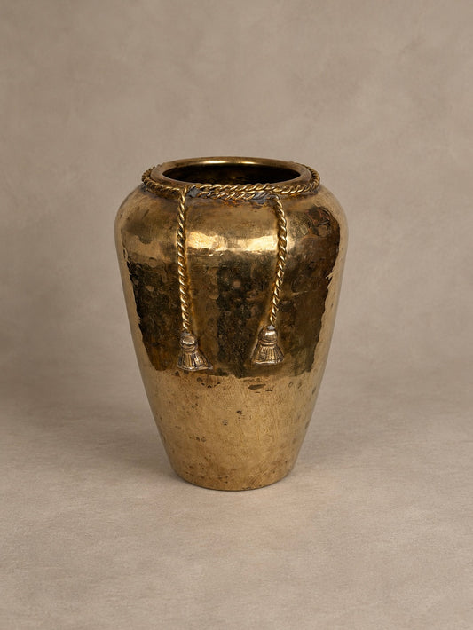 Brass vase with a rounded tapered body, twisted rope detailing around the rim and two decorative hanging tassels.